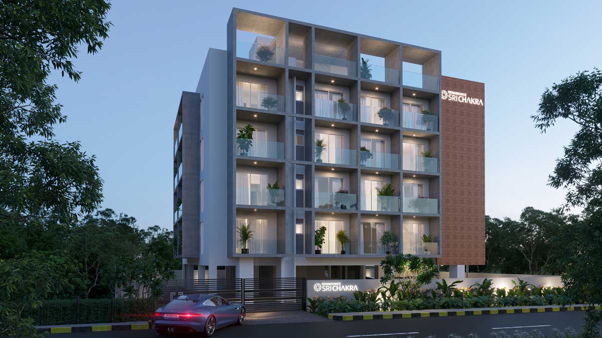 Evening view of Renaissance Sri Chakra with lit balconies, a brick-clad feature wall and the gated entrance
